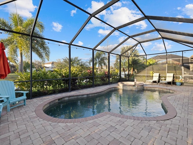 view of swimming pool with an in ground hot tub, a patio, and glass enclosure