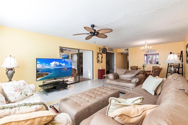 living room featuring ceiling fan with notable chandelier, tile patterned floors, and a textured ceiling