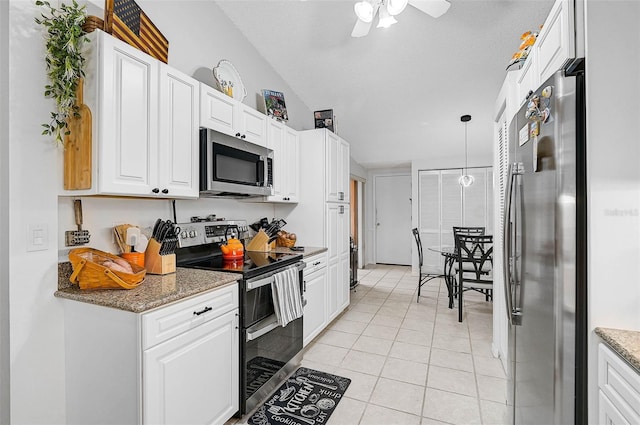 kitchen featuring light tile patterned flooring, white cabinetry, decorative light fixtures, appliances with stainless steel finishes, and dark stone counters