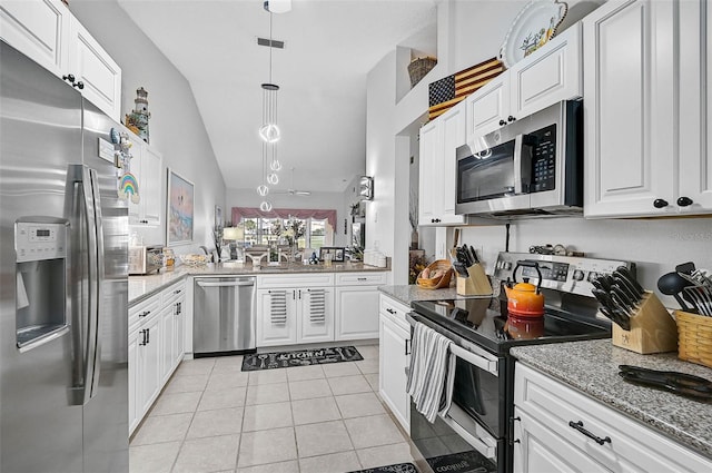 kitchen featuring light stone counters, light tile patterned floors, appliances with stainless steel finishes, pendant lighting, and white cabinets