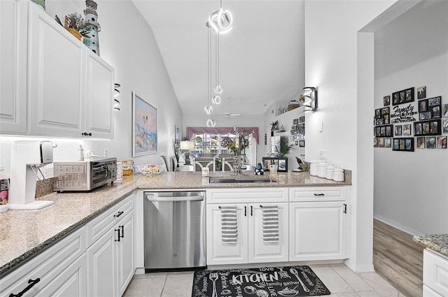 kitchen with light stone counters, white cabinets, and dishwasher