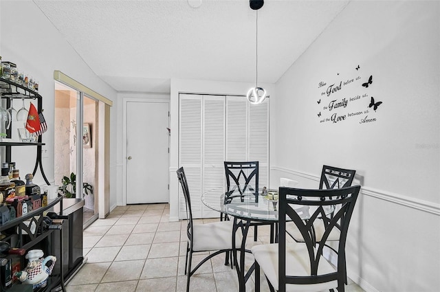 tiled dining area with a textured ceiling