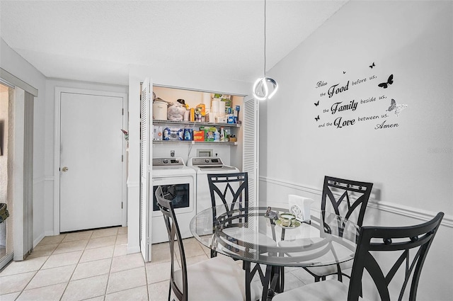 tiled dining area featuring washing machine and dryer and a textured ceiling