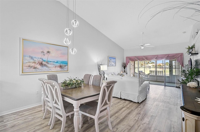 dining space with ceiling fan, high vaulted ceiling, and light hardwood / wood-style flooring