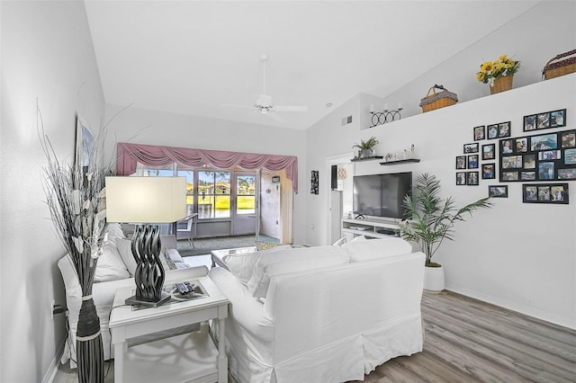 living room featuring lofted ceiling, hardwood / wood-style flooring, and ceiling fan