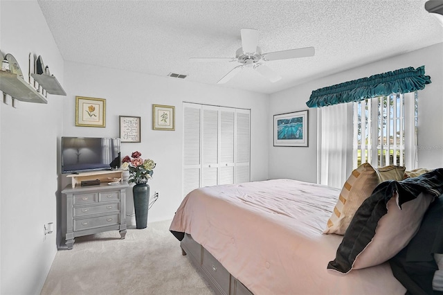 carpeted bedroom featuring ceiling fan, a closet, a textured ceiling, and access to exterior