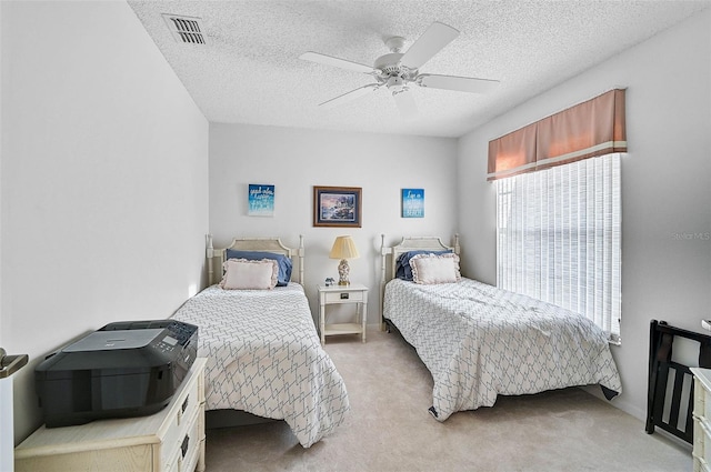 carpeted bedroom with ceiling fan and a textured ceiling