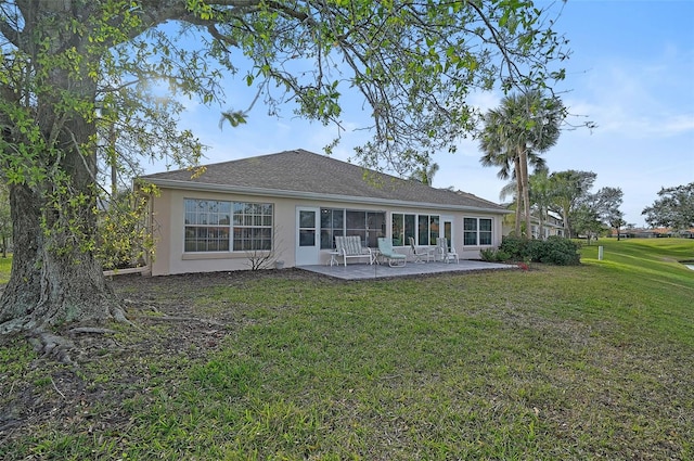 back of property featuring a lawn and a patio