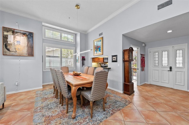 dining space featuring crown molding and light tile patterned flooring