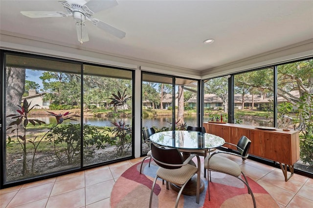 sunroom with a water view and ceiling fan