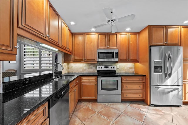 kitchen featuring sink, backsplash, stainless steel appliances, and dark stone counters