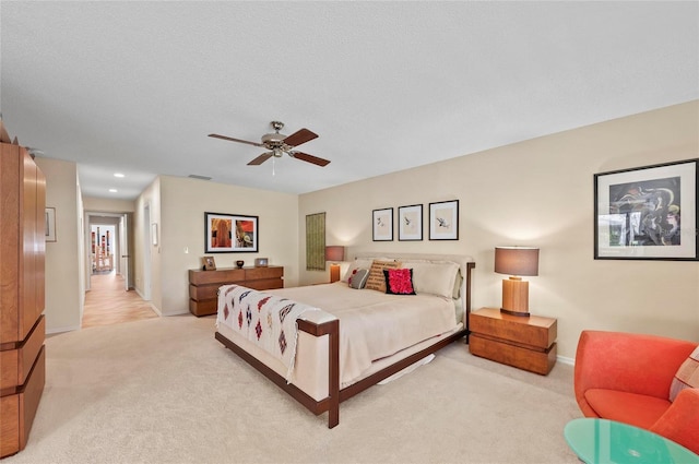 carpeted bedroom with ceiling fan and a textured ceiling