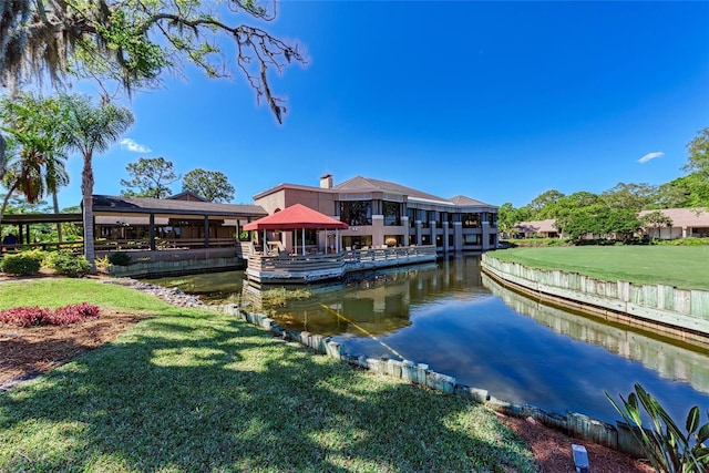 view of dock featuring a gazebo, a water view, and a lawn