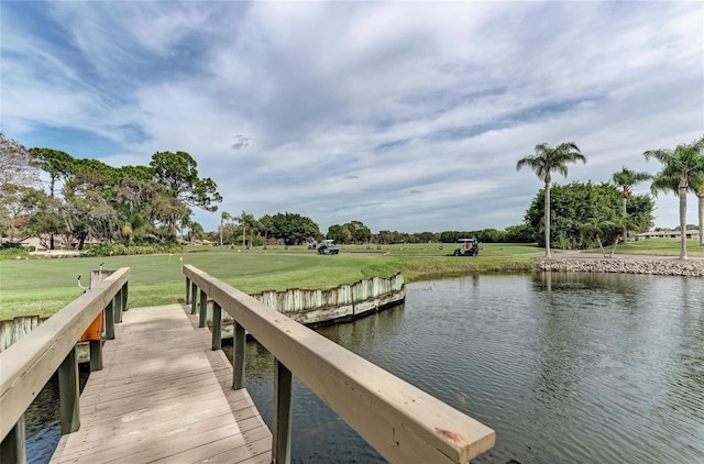 dock area with a water view and a lawn