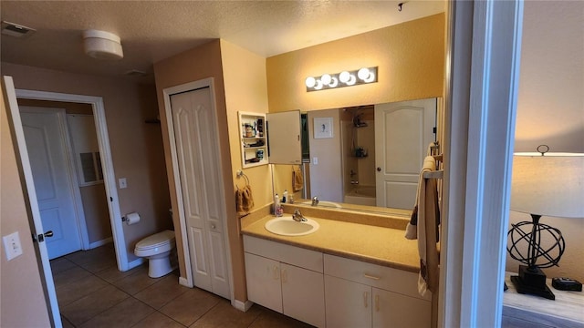 full bathroom with tile patterned floors, bathtub / shower combination, toilet, a textured ceiling, and vanity