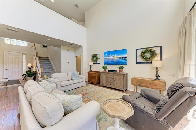 living room with light hardwood / wood-style floors and a high ceiling