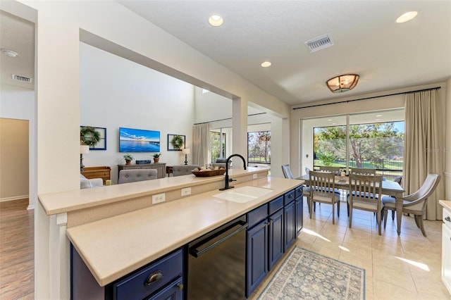 kitchen featuring dishwasher, sink, a wealth of natural light, and blue cabinetry