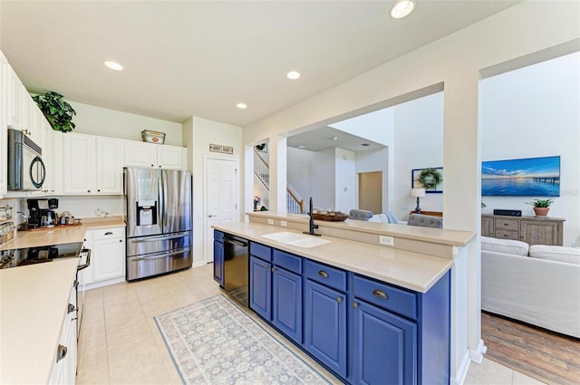 kitchen featuring white cabinetry, sink, black appliances, and blue cabinetry