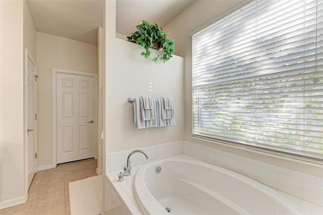 bathroom with tile patterned flooring and tiled tub