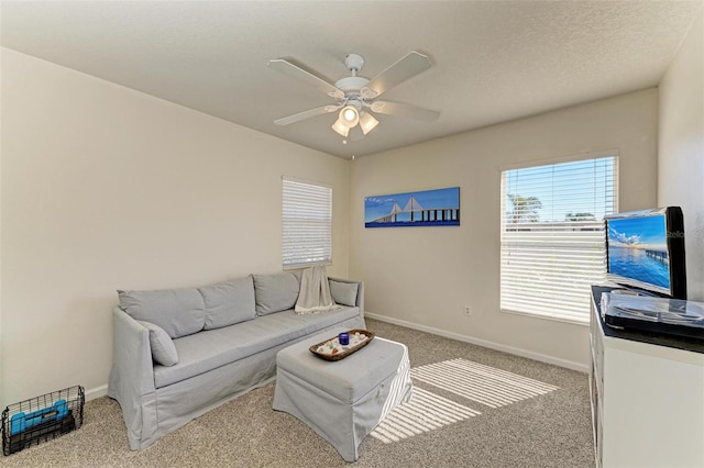 living room featuring a textured ceiling, ceiling fan, and carpet