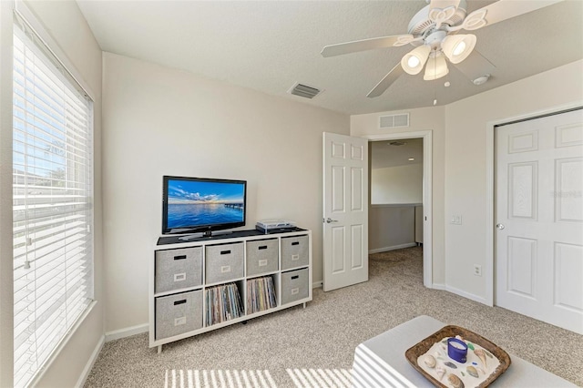 interior space featuring ceiling fan and light carpet