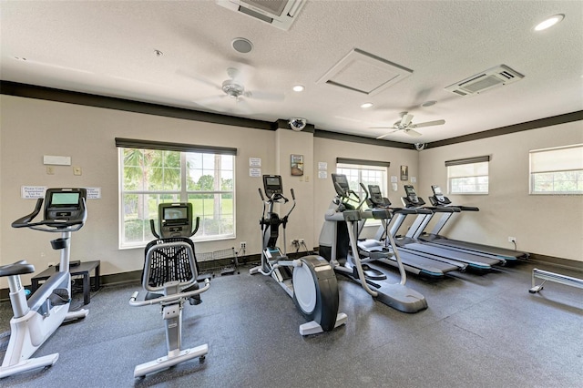 exercise room with ceiling fan, a textured ceiling, and a wealth of natural light