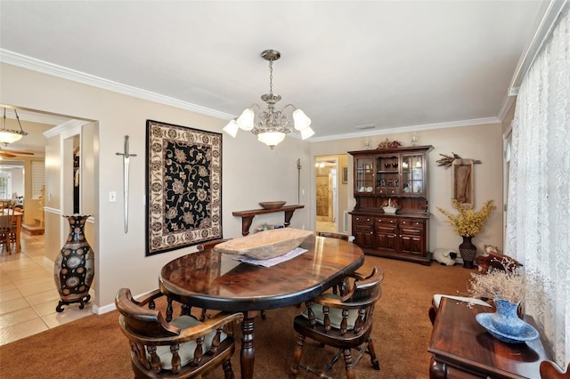 dining space featuring ornamental molding, light colored carpet, and an inviting chandelier