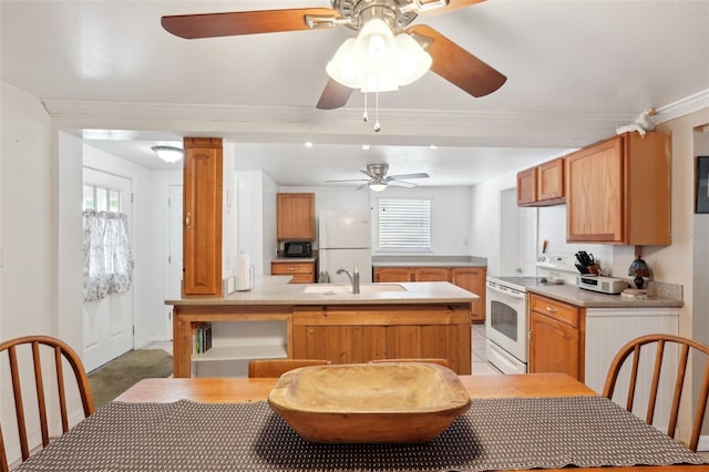 kitchen featuring sink, crown molding, white appliances, kitchen peninsula, and ornate columns