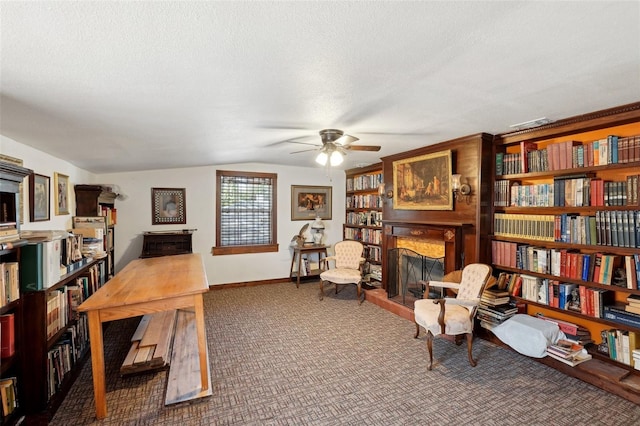 carpeted office with lofted ceiling, ceiling fan, and a textured ceiling