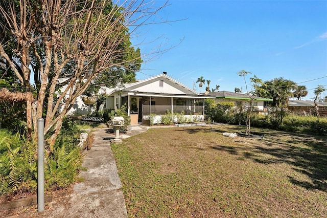 exterior space with a sunroom and a lawn