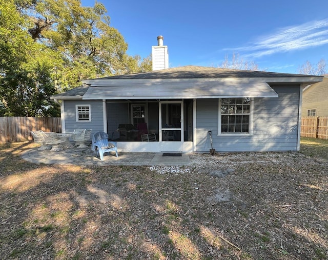 rear view of house with a patio and a sunroom