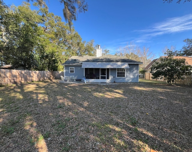 rear view of property featuring a sunroom