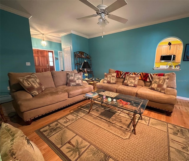 living room with hardwood / wood-style flooring, ornamental molding, and ceiling fan