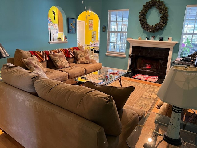 living room featuring a tiled fireplace, hardwood / wood-style flooring, and a wealth of natural light