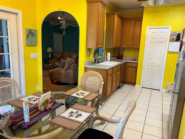 kitchen featuring light tile patterned floors, ornamental molding, sink, and ceiling fan