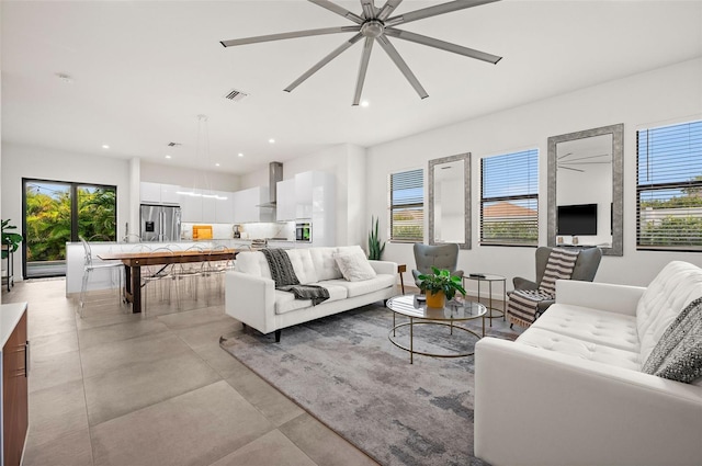 living room with ceiling fan and a healthy amount of sunlight