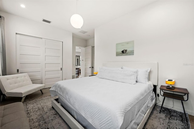 bedroom with dark wood-type flooring and a closet