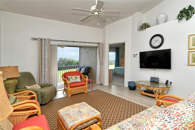 living room featuring ceiling fan, wood-type flooring, and a textured ceiling