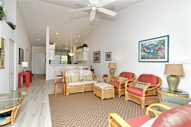 living room with high vaulted ceiling, light wood-type flooring, and ceiling fan