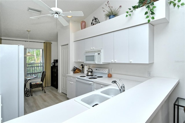 kitchen with sink, kitchen peninsula, white appliances, light hardwood / wood-style floors, and white cabinets