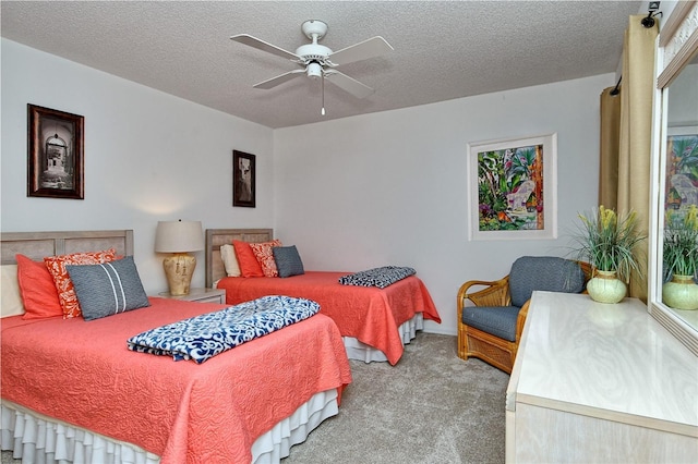 carpeted bedroom featuring ceiling fan and a textured ceiling