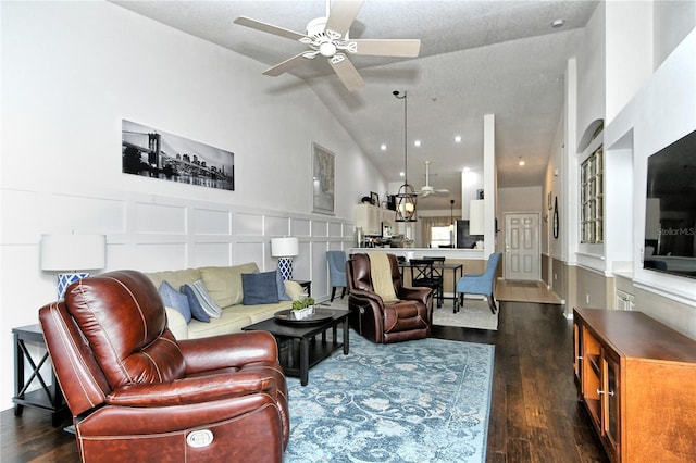 living room featuring lofted ceiling, dark wood-type flooring, and ceiling fan