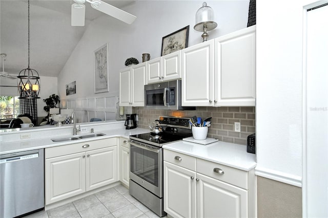 kitchen featuring sink, white cabinetry, pendant lighting, stainless steel appliances, and backsplash