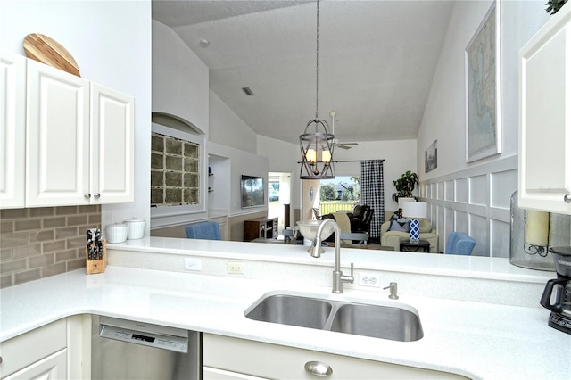 kitchen featuring lofted ceiling, sink, white cabinetry, stainless steel dishwasher, and a chandelier