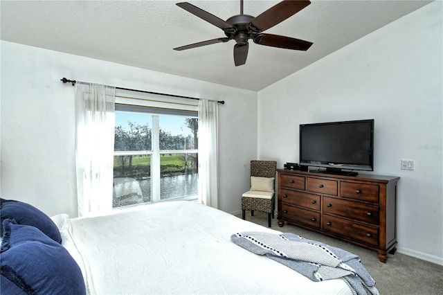 bedroom featuring a textured ceiling, vaulted ceiling, light colored carpet, and ceiling fan