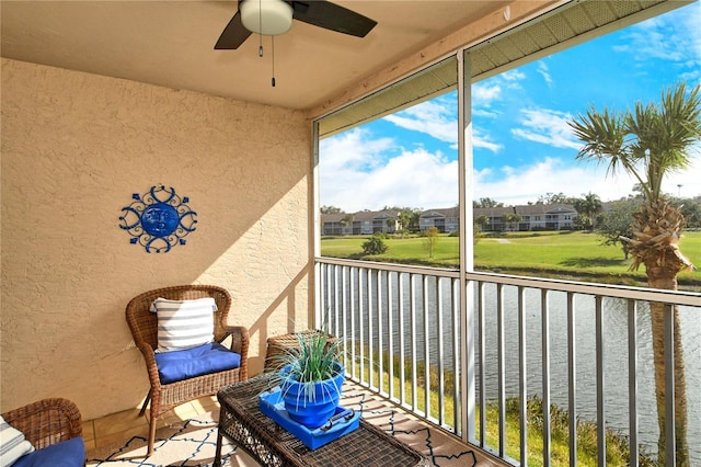 sunroom with a water view and ceiling fan