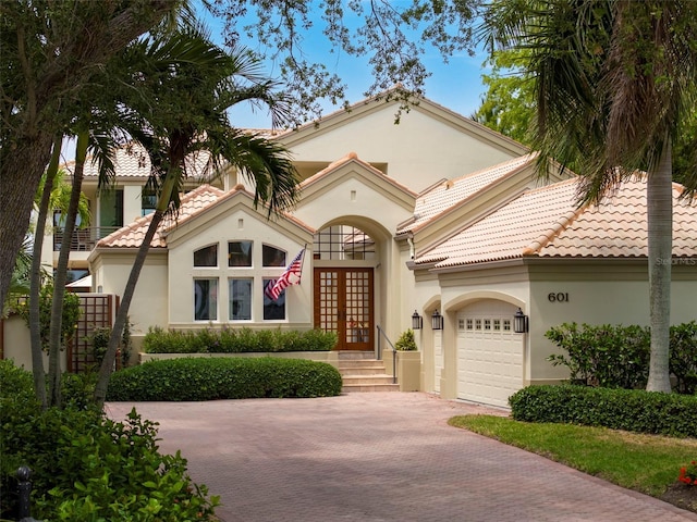 mediterranean / spanish home with a garage and french doors