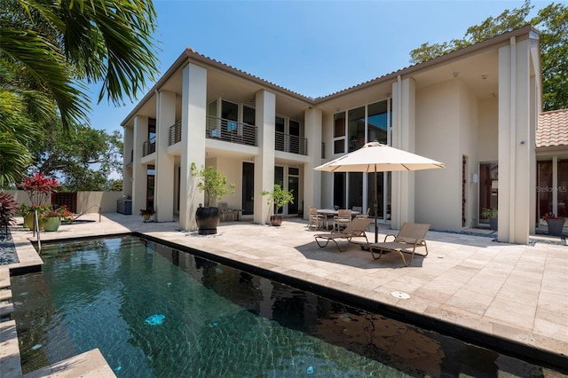 back of property featuring a fenced in pool and a patio area