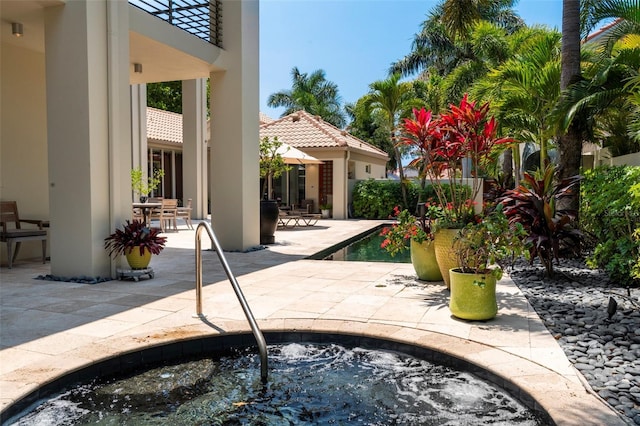 view of pool featuring an in ground hot tub and a patio