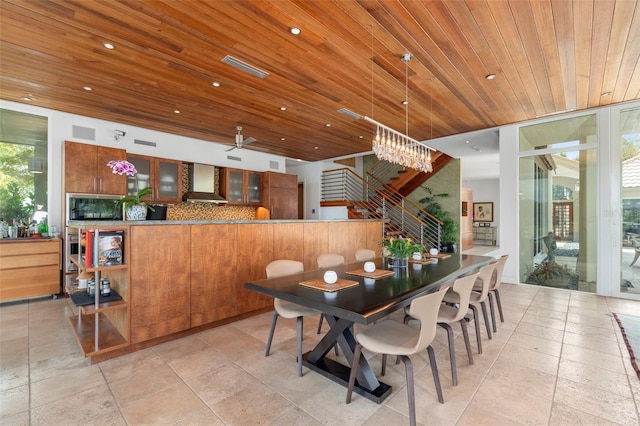 dining area featuring ceiling fan with notable chandelier and wood ceiling